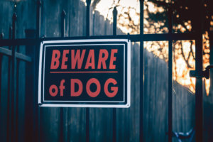 Sign warning others about their dog, abiding dog bite laws.